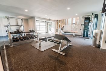 a home gym with weights and cardio equipment and a window